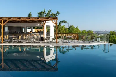 a pool of water with chairs and a bar at Atalanti Boutique Hotel - Adults Only in Faliraki