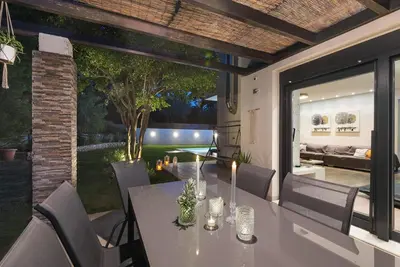 a dining room with a table and a patio at Green horizon villa in Asgourou