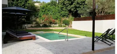 a swimming pool with an umbrella in a yard at Green horizon villa in Asgourou