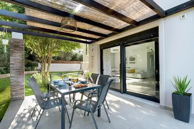 a dining room with a table and chairs on a patio at Green horizon villa in Asgourou