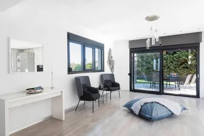 a white living room with chairs and a table at Green horizon villa in Asgourou