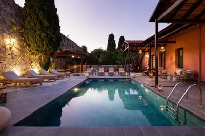 a swimming pool with lounge chairs and a house at Villa Fluvian in Rhodes Town