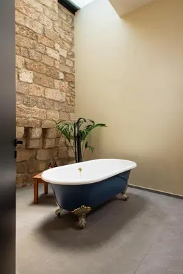 a bath tub in a room with a brick wall at Villa Fluvian in Rhodes Town
