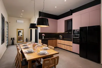 a dining room with a table and a kitchen at Villa Fluvian in Rhodes Town