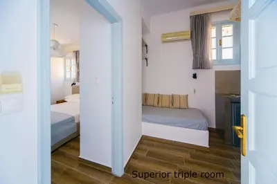 a bedroom with two beds and a sliding door at St. Paul's Bay View Suites in Líndos