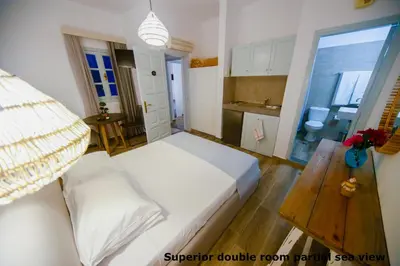a small room with a bed and a kitchen at St. Paul's Bay View Suites in Líndos
