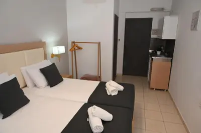 a hotel room with a bed with towels on it at ANGELA STUDIOS in Kremasti