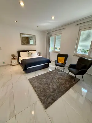 a bedroom with a king sized bed and two chairs at Villa 56 Luxury apartments in Rhodes Town