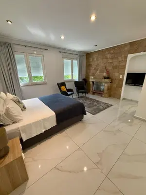 a bedroom with a king sized bed and a fireplace at Villa 56 Luxury apartments in Rhodes Town