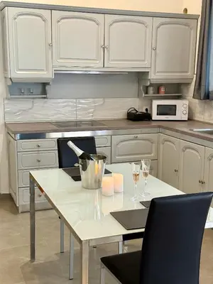 a kitchen with white cabinets and a table with wine glasses at Villa 56 Luxury apartments in Rhodes Town