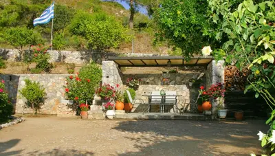 a patio with a table and flowers and a flag at Dora's House in Ístrios