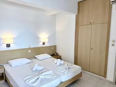 a bedroom with a bed with two white towels on it at Savoy City Hotel in Rhodes Town