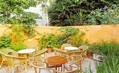 a patio with tables and chairs and a fence at Savoy City Hotel in Rhodes Town