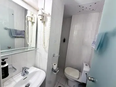 a white bathroom with a sink and a toilet at Savoy City Hotel in Rhodes Town