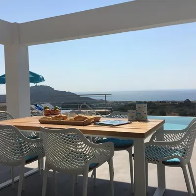 a table and chairs on a balcony with a view at Luxury Villa Hera with Private Pool in Afantou