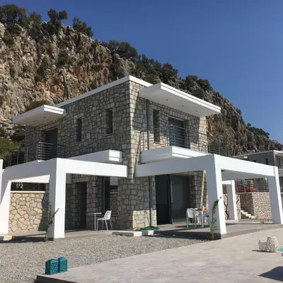 a large brick building with a mountain in the background at Luxury Villa Hera with Private Pool in Afantou