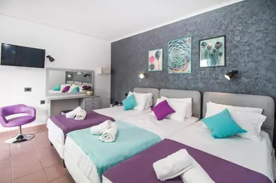 a bedroom with two beds with towels on them at Kahlua Hotel Apartments in Rhodes Town
