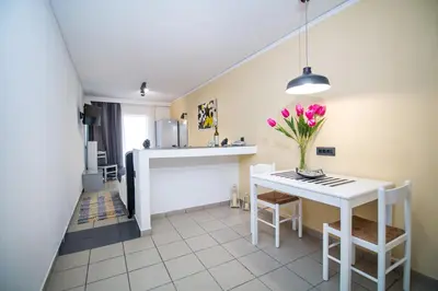 a kitchen with a white table and a vase of flowers at Kahlua Hotel Apartments in Rhodes Town