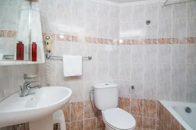 a bathroom with a white toilet and a sink at Kahlua Hotel Apartments in Rhodes Town