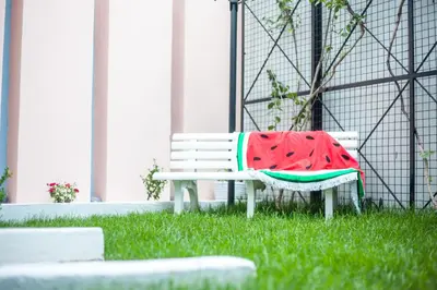 a watermelon blanket on a bench in the grass at Kahlua Hotel Apartments in Rhodes Town