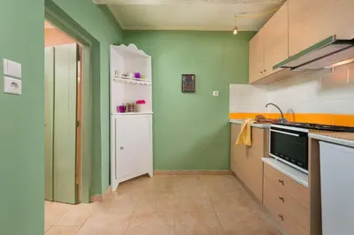 a kitchen with green walls and a white refrigerator at Colourful Home, Medieval Town Rhodes in Rhodes Town