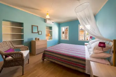 a bedroom with blue walls and a bed and a chair at Colourful Home, Medieval Town Rhodes in Rhodes Town