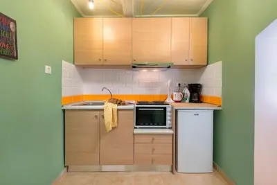 a small kitchen with wooden cabinets and a microwave at Colourful Home, Medieval Town Rhodes in Rhodes Town