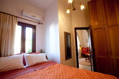 a bedroom with a bed and a window and a mirror at Nikelen Lindian Exclusive Apartments in Líndos