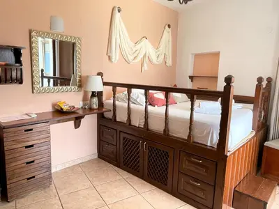 a bedroom with a bed with a dresser and a mirror at Nikelen Lindian Exclusive Apartments in Líndos
