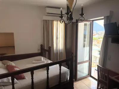 a bedroom with a bed and a sliding glass door at Nikelen Lindian Exclusive Apartments in Líndos