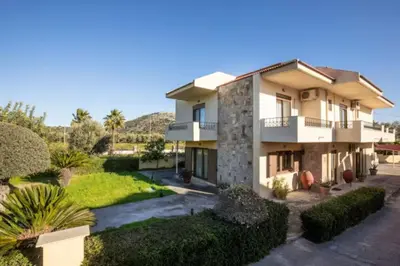 an image of a house with bushes and trees at Savvinas House Faliraki-Traganou Beach in Faliraki