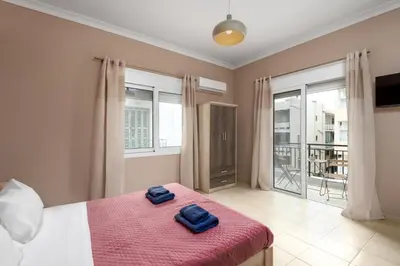 a bedroom with a bed with two blue towels on it at TownHall Apartment's in Rhodes Town