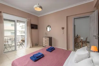 a bedroom with a large bed with two blue towels on it at TownHall Apartment's in Rhodes Town