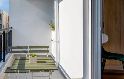 a stairway with a green bench on a balcony at TownHall Apartment's in Rhodes Town