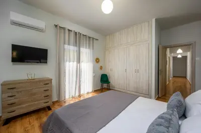 a bedroom with a bed and a dresser and a television at TownHall Apartment's in Rhodes Town