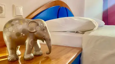 a statue of an elephant on a table next to a bed at Nitsa's Apartments in Megálon Choríon