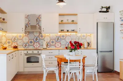 a kitchen with white cabinets and a table and chairs at Anatoli Traditional Villa in Archangelos