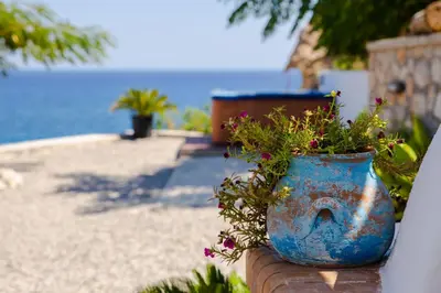 a blue vase filled with flowers sitting on a wall at Anatoli Traditional Villa in Archangelos