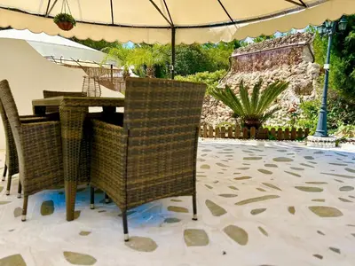 a table and chairs with an umbrella on a patio at Nicole Luxury Villas in Koskinou