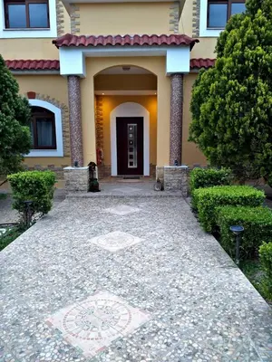 a house with a stone walkway leading to a door at Nicole Luxury Villas in Koskinou