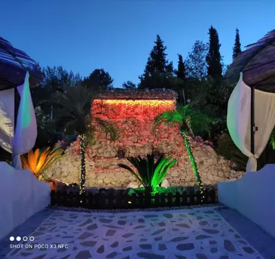 a garden at night with a lit up fountain at Nicole Luxury Villas in Koskinou