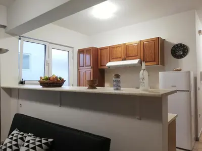 a kitchen with wooden cabinets and a bowl of fruit on a counter at Casa Dama in Rhodes Town