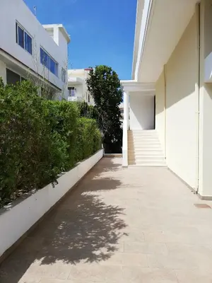 a walkway next to a white building with bushes at Casa Dama in Rhodes Town