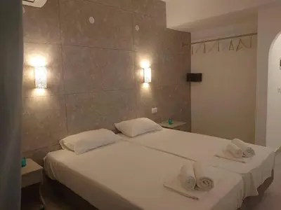 a bedroom with a white bed with two towels on it at Ikaros Studios in Faliraki