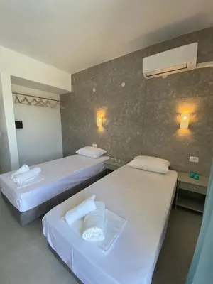 a hotel room with two beds and two lights on the wall at Ikaros Studios in Faliraki