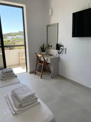 a white room with a bed and a mirror at Ikaros Studios in Faliraki