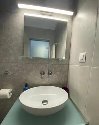 a bathroom with a white sink and a mirror at Ikaros Studios in Faliraki