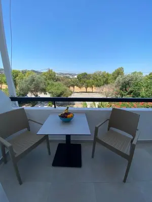 a table and two chairs sitting on a balcony at Ikaros Studios in Faliraki