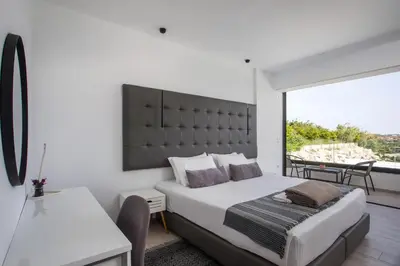 a bedroom with a large bed and a balcony at Habitat Inn Faliraki View Villa Rhodes in Kalithies