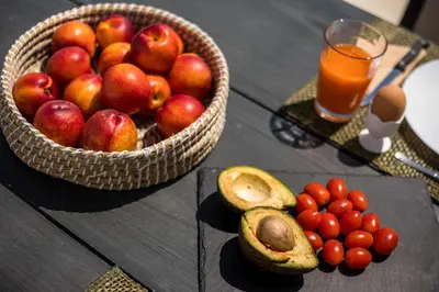 a basket of fruit on a table with a glass of orange juice at Habitat Inn Faliraki View Villa Rhodes in Kalithies
